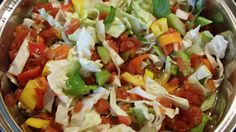 a metal bowl filled with lots of different types of salads on top of it