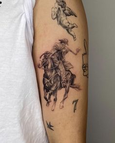 a man with a tattoo on his arm that has two horses and an angel on it