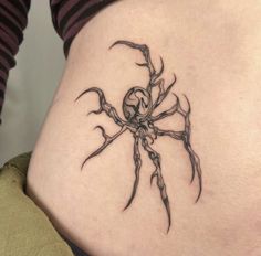 a woman's stomach with a spider tattoo on her lower back and the bottom part of her abdomen