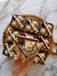 a person holding up a piece of cake with chocolate and bananas on it in front of a marble counter top