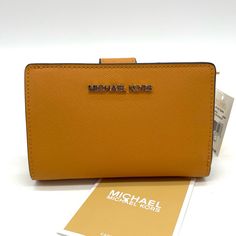 Brand New With Tag Michael Kors Medium Bifold Wallet 100% Leather From Tanneries Meeting The Highest Standards Of Environmental Performance Wallet Crossgrain Leather 100% Leather Color: Cider Gold-Tone Hardware 5.25"W X 3.5"H X 1.25"D Interior Details: 1 Zip Pocket, 3 Slip Pockets, 6 Card Slots, Id Window Lining: 100% Polyester Snap Fastening Dust Bag Not Included Imported Michael Kors Gold Wallet For Everyday Use, Yellow Leather Travel Wallets, Gold Michael Kors Wallet For Everyday Use, Everyday Michael Kors Bifold Wallet, Yellow Leather Wallet For Everyday Use, Michael Kors Leather Wallet For Daily Use, Yellow Leather Rectangular Wallet, Michael Kors Leather Bifold Bag, Michael Kors Leather Wallets