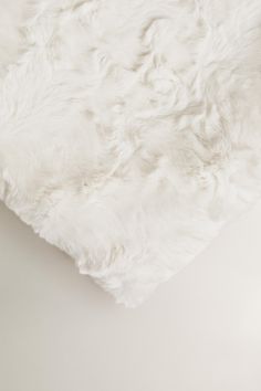 a white fur pillow on top of a table