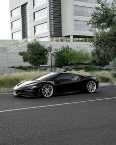 a black sports car parked in front of a tall building