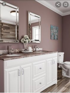 a bathroom with two sinks, mirrors and a toilet in the middle of the room