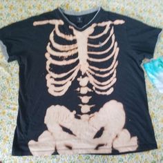 a t - shirt with a skeleton on it is laying on a floral print sheet