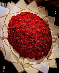 a large bouquet of red roses sitting on top of a table