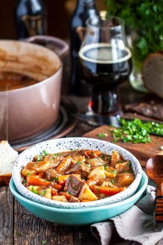 a bowl filled with stew next to bread