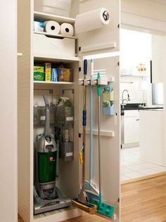 an open cabinet with cleaning supplies in it