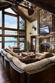 a living room filled with lots of furniture and a fire place in front of a large window