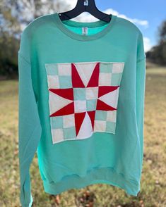 Repurposed upcycled vintage quilt block sweatshirt. Made from a beautiful vintage Christmas inspired cutter quilt.  This one of a kind sweatshirt is a unisex Jerzees brand Adult size Medium crewneck. Rare Find. Turquoise Vibes. The Jerzees NuBlend Fleece Crew offers optimal comfort and durability. Crafted from a 50/50 cotton-polyester blend, this 8 oz. fleece is designed for smooth customization. Available in over 40 vibrant colors, it features a tear-away label, seamless body, and high-stitch density, optimal for a polished finish in any project. Ideal for DTF Transfers, sublimation, and more, customers love its softness and true-to-size fit, making it a top choice for quality and adaptability in crafting circles. Features 8 oz., 50% cotton, 50% polyester Oxford is 49% cotton, 51% polyest Repurposed Quilt, Upcycled Quilt, Roommate Gifts, Patchwork Sweatshirt, Unique Gifts For Mom, Vintage Quilt, Upcycled Vintage, Vintage Quilts