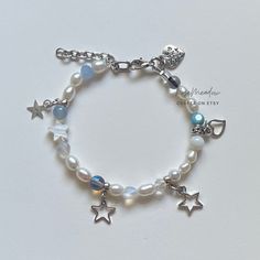 "A sweet handmade bracelet ✿ Made with freshwater pearls, Quartz, mother of Pearl, glass, glass crystal, and metal accents ✿ Pearlescent white, icy blue, iridescent clear, sky blue, frosted clear, black, and silver ✿ The bracelet has an additional 1-1.5\" of extension chain I paired this bracelet with the Mystic Pearl bracelet which is also available in my shop!" Silver And Blue Bracelet, Handmade White Pearl Charm Bracelet, Handmade Pearl Crystal Bracelet In Silver, White Pearl Charm Bracelets For Jewelry Making, Handmade Silver Pearl Crystal Bracelet, Handmade White Pearl Crystal Bracelet, Mother Of Pearl Bracelet, Bracelets Design, Diy Bracelet Designs