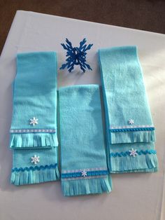 four pieces of blue cloth with snowflakes on them sitting on top of a table