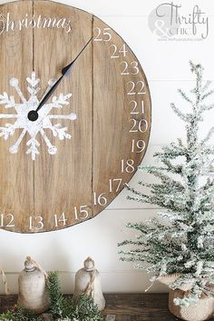 a wooden clock with white snowflakes on the face and numbers painted on it