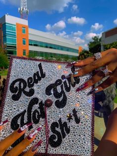 two hands holding up a graduation cap that says real girls do it