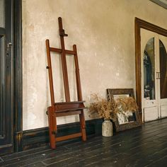 an easel sitting on the floor next to a mirror