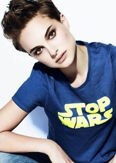 a woman sitting on the ground with her hands in her pockets and wearing a star wars shirt