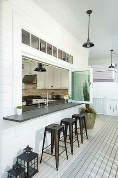 an image of a kitchen setting with stools in front of the counter and window