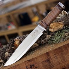 a knife sitting on top of a piece of wood