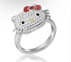 a hello kitty ring with red and yellow stones on the front, sitting on a white surface