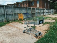 an empty shopping cart sitting in the middle of a yard