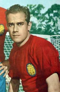 an old photo of two men in red shirts and one is holding a soccer ball