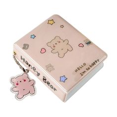 a pink box with a keychain attached to it and a small teddy bear on the front