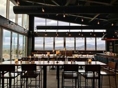 an empty restaurant with large windows overlooking the mountains