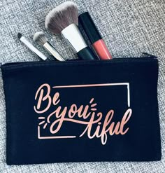 the makeup bag has brushes in it and is on top of a gray carpeted surface