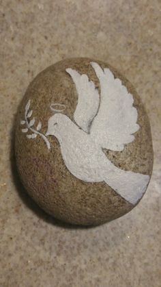 a rock with a dove painted on it