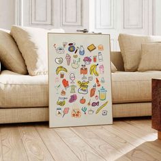 a living room with a couch, coffee table and pictures on the wall in front of it