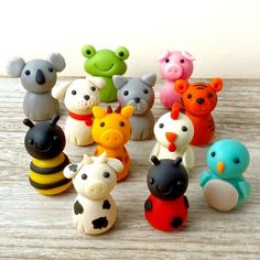 a group of small toy animals sitting next to each other on a wooden table top