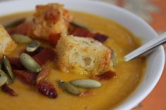 a white bowl filled with soup and croutons