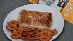 a white plate topped with cookies and pretzels next to a bag of cereal