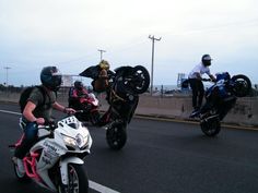 three people riding motorcycles on the road