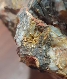 a close up view of some rocks with gold flecks on it's surface