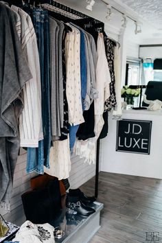 clothes and shoes are hanging on racks in a clothing store