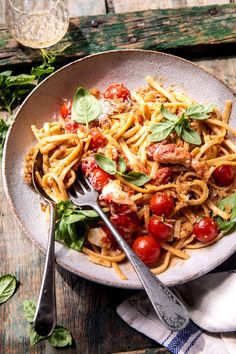 a plate of pasta with tomatoes and basil