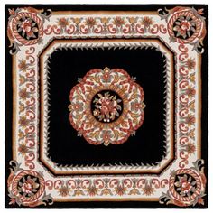 a black and red rug with an ornate design on the center, surrounded by flowers