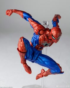 the action figure spider - man is posed on a clear stand with his arms outstretched