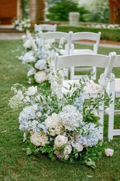 white and blue flowers line the aisle of chairs at a wedding ceremony in an outdoor setting