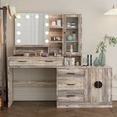 a wooden desk topped with a mirror next to a dresser and shelf filled with items