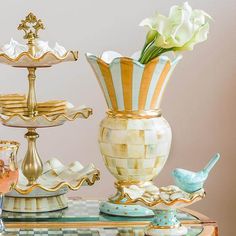 a table topped with three tiered trays filled with vases and flowers next to each other