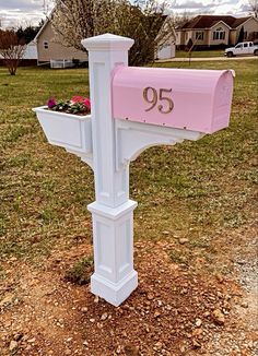 a pink mailbox with flowers in it