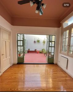 an empty room with wooden floors and green doors