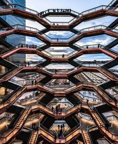 people are walking up and down the escalators in this modern building with glass windows