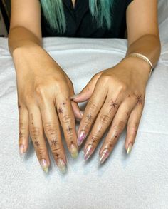 a woman with green hair and tattoos on her hands