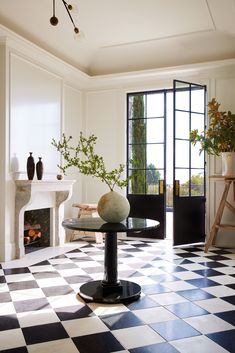 a black and white checkered floor in a living room with an open fire place