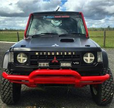 the front end of a black and red truck