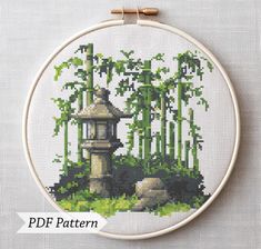 a cross stitch pattern with a pagoda in the middle surrounded by bamboo trees and rocks