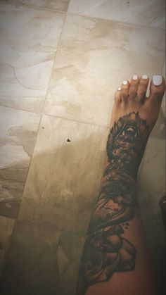 a woman's arm with a tattoo on it and her foot in the air